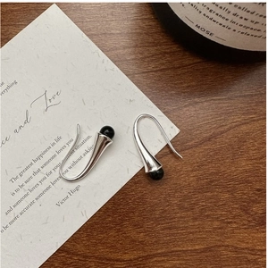 Detail of S925 sterling silver curved hook earrings with black spherical stone accents