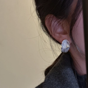 S925 sterling silver feather leaf stud earrings with detailed texture worn by a model