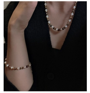 Vue macro du collier en argent S925 avec perles naturelles et œil de tigre sur tricot noir