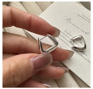 Détail de boucles d'oreilles géométriques en argent S925 avec finition polie et poinçonnage