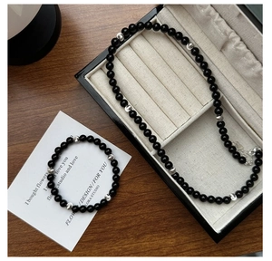 Macro view of black onyx beaded jewelry set with silver spacers and lobster clasp detail