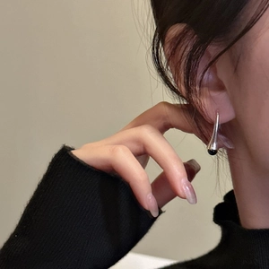 Minimalist S925 sterling silver drop earrings with black bead on model with beige background