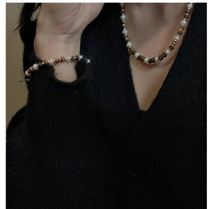 Détail de l'ensemble collier et bracelet en argent S925 avec perles blanches et œil de tigre