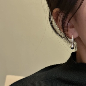 Minimalist S925 sterling silver drop earrings with dark bead worn by a model
