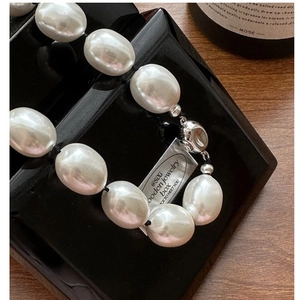 Macro della chiusura in argento S925 e collana con perle barocche e carta del marchio