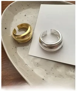 Detail shot of matte gold and silver open rings with thick irregular irregular streamlines