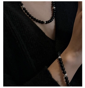 Close-up of S925 silver and black onyx bead necklace and bracelet set on neck and wrist