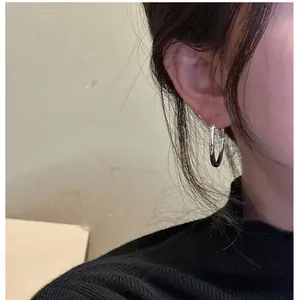 Close-up of minimalist S925 sterling silver hoop earrings with high polish finish