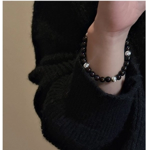 Close-up of S925 sterling silver beaded bracelet with dark onyx on a black sweater