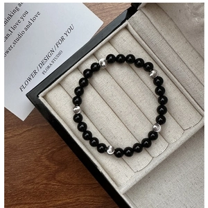 Detail of S925 silver irregular beads and black agate stones in a premium jewelry box