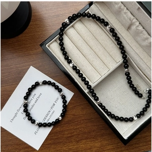 Detail of S925 silver black onyx beaded necklace and bracelet set on jewelry display box