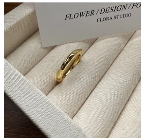 Detailed view of S925 silver ring with golden lava texture on a beige canvas tray