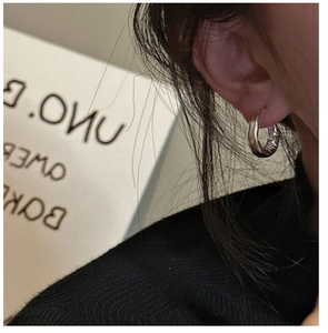 Primo piano di orecchini a cerchio in argento sterling S925 con texture stropicciata