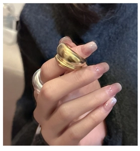Macro detail of minimalist double-layered matte rings in silver and gold finishes