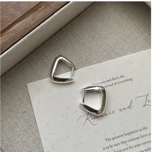 Gros plan de boucles d'oreilles créoles triangles en argent S925 avec finition polie