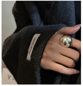 Close-up of a large polished silver spherical ring on model with minimalist modern design