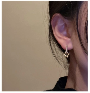 Close-up of minimalist S925 sterling silver square hoop earrings on a model