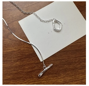 Macro detail of S925 sterling silver long necklace with toggle clasp and asymmetric chain