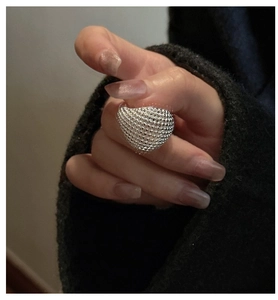 Macro view of S925 sterling silver beaded ring on finger with textured granular finish
