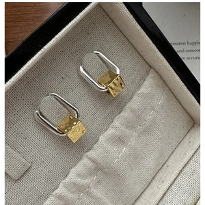 Detail of S925 silver U-shaped earrings with hand-hammered gold square pendants