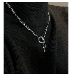 Detail of silver S925 double-layer necklace with OT buckle on dark knit sweater