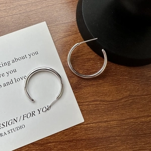 Minimalist S925 sterling silver C-shaped hoop earrings on a vintage wooden surface