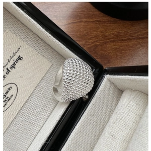 Detailed macro view of S925 sterling silver dome ring with textured metal grain finish