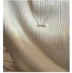 Detail of silver S925 necklace with dual freshwater pearls on a bar worn on a sweater
