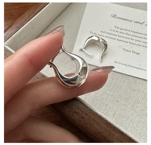 Gros plan sur des boucles d'oreilles en argent S925 en forme de U au design minimaliste