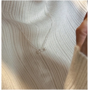 Close-up of S925 sterling silver bar necklace with dual pearls on a knit sweater
