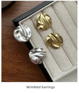 Detail of 925 sterling silver stud earrings with gold and silver crinkle texture