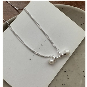 Detail shot of S925 silver necklace with two pearls on a modern horizontal bar pendant