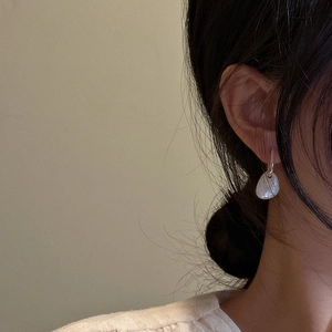 Minimalist S925 sterling silver drop earrings with white shell textures on a female model
