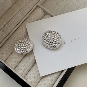 Detailed close-up of S925 sterling silver ball-textured stud earrings on a velvet display