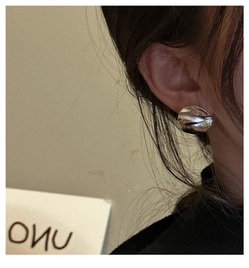 Detail of 925 sterling silver stud earrings with irregular liquid metal texture finish