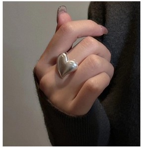 Macro view of a chunky S925 sterling silver heart ring with a polished mirror finish