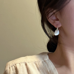 Elegant S925 sterling silver hoop earrings with irregular white shell drops on model