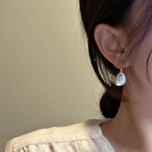 Elegant S925 silver earrings with irregular white shell drops on a female model