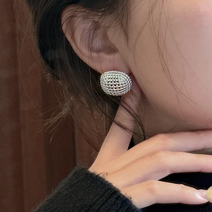 Minimalist S925 sterling silver ball drop earrings with textured pattern on a model