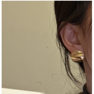 Close-up of gold 925 silver earrings featuring a unique textured wrinkled surface design