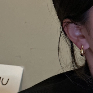 Boucles d'oreilles gouttes dorées en argent S925 portées par un mannequin