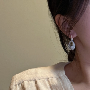 Minimalist S925 sterling silver teardrop hollow earrings worn on a model with warm lighting