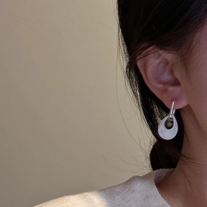 S925 sterling silver shell drop earring on model featuring a hollow teardrop design