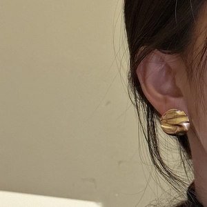 925 silver irregular gold textured stud earrings with a crumpled finish on the model