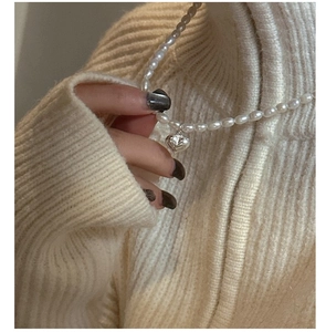 Gros plan du collier de perles naturelles et pendentif cœur en argent S925