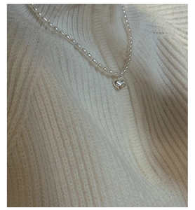 Gros plan d'un collier en argent S925 avec perles naturelles et pendentif en cœur