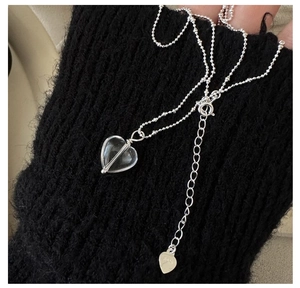 Dettaglio della collana in argento S925 con ciondolo a cuore in cristallo su tessuto nero