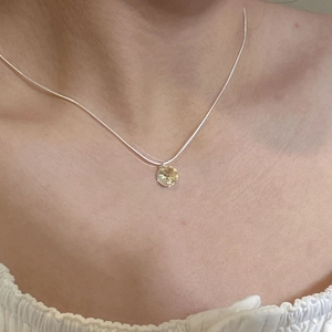 Gros plan du collier en argent S925 avec pendentif rond en cristal jaune sur le mannequin