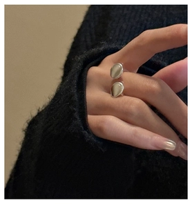 Close-up of minimalist S925 silver open ring with dual oval cat eye stones on finger