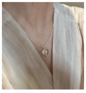 Primo piano della collana con ciondolo a cuore in cristallo indossata sul collo